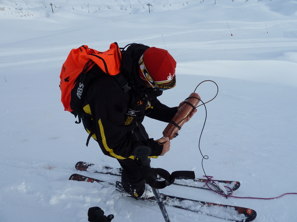 A ski patrol fixing a catex charge - high prone avalanche terrain