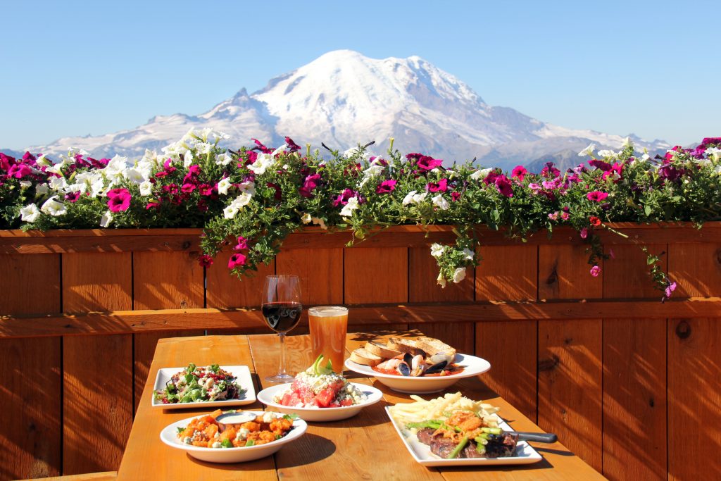 A table with a view of Mount Rainer- Crystal Mountain Resort in Washington state acquired by Alterra Mountain Company.