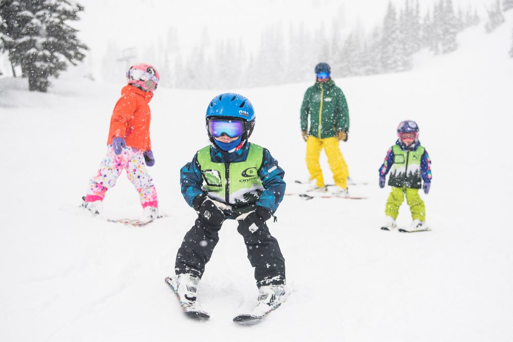 Kids skiing in Crystal Mountain during a snowy day. 