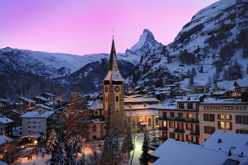 Zermatt at night, with the majestic Matterhorn viewing over it. 