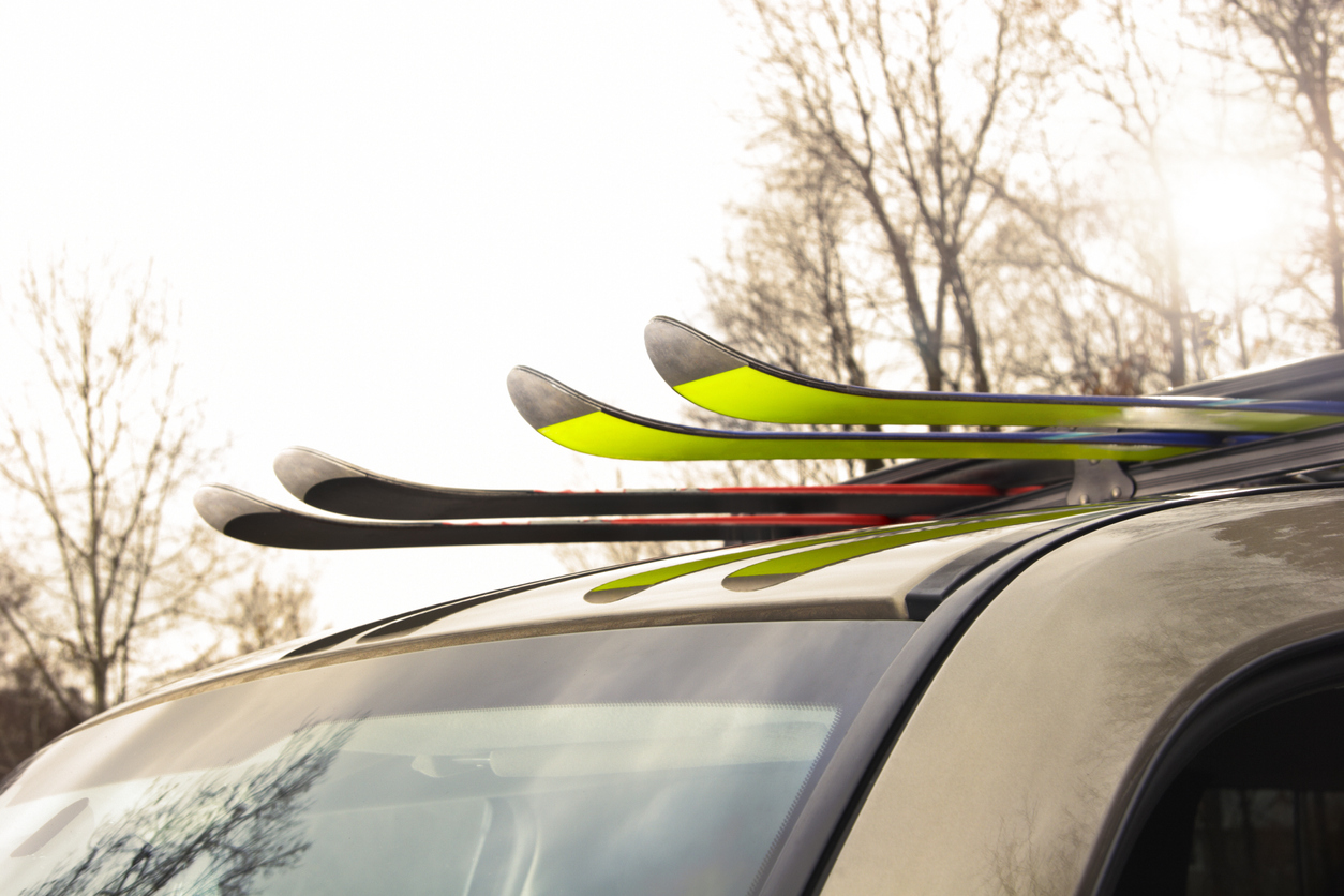 Two pairs of skis loaded into a ski rack on top of car. Heading out for a day of outdoor fun on the ski slopes.Photo: ICarhireinsurance.com - Skiers Over New Year Prepare for a £450 Wipeout at the Car Hire Rental Desk.