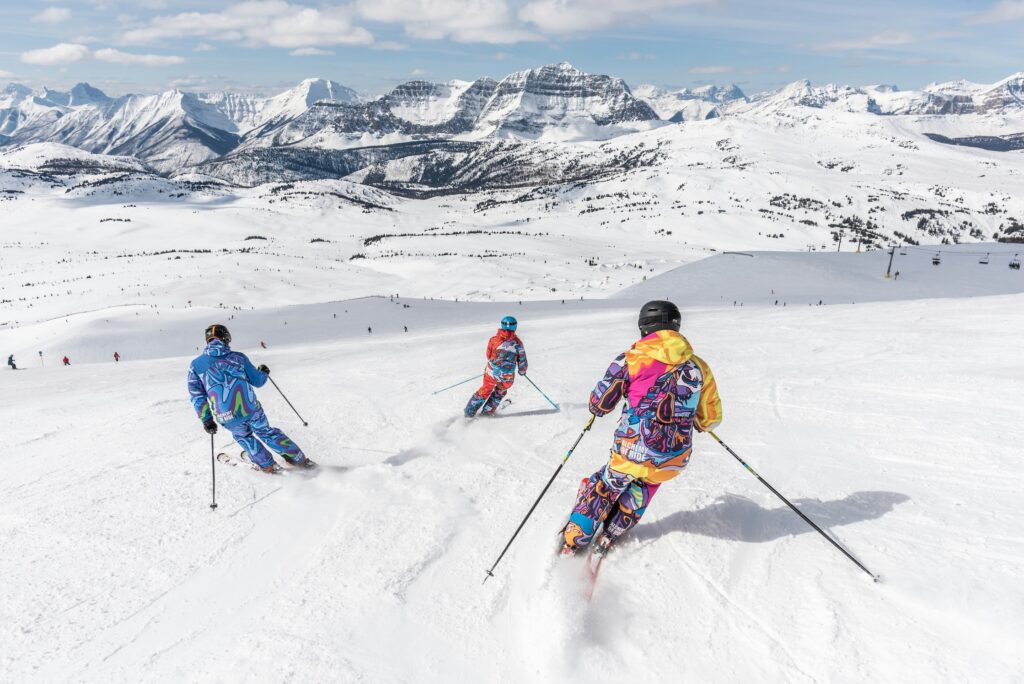 Three skiers enjoying the snow and views of Banff Sunshine Village. Photo: Banff Sunshine Village Resort. Unsplash. Mountain Doctors publishes accident figures.